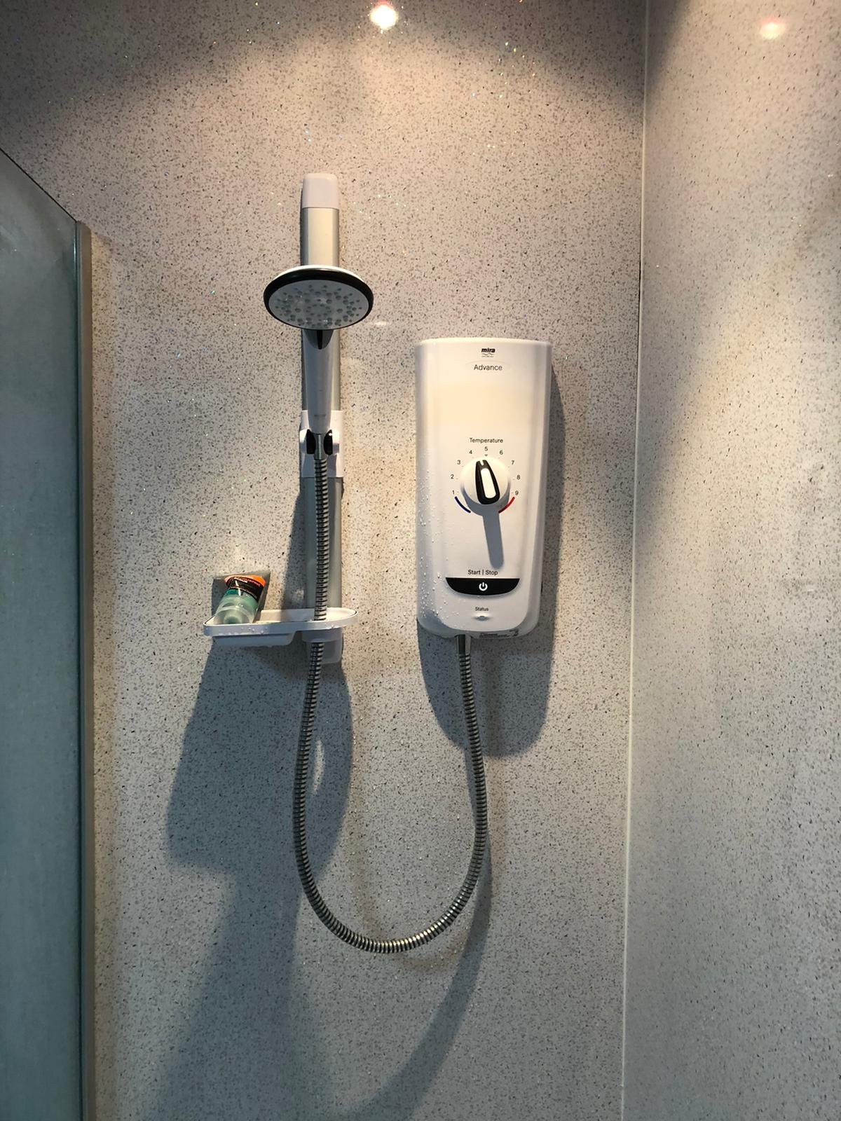 Electric shower installation with wall-mounted Mira Advance unit for bathroom renovation by certified electricians in Manchester